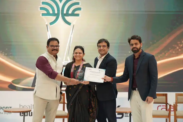A KIS educator receiving her certificate on stage from three guests