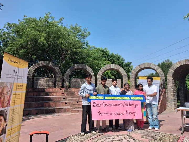 Students holding a banner that thanks grandparents, in an open-air amphitheatre