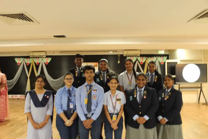 Students of the Interact Club in school uniform standing together in a hall